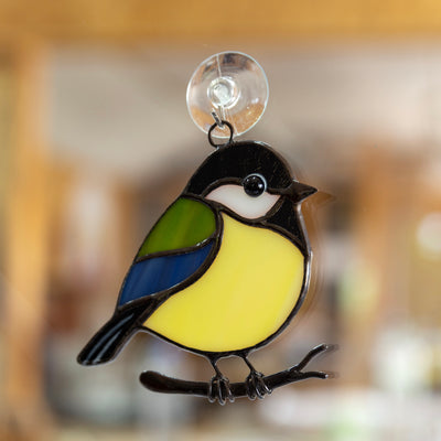 Stained glass black chickadee sitting in the branch suncatcher