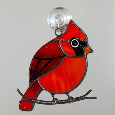Stained glass suncatcher of a cardinal sitting on the branch