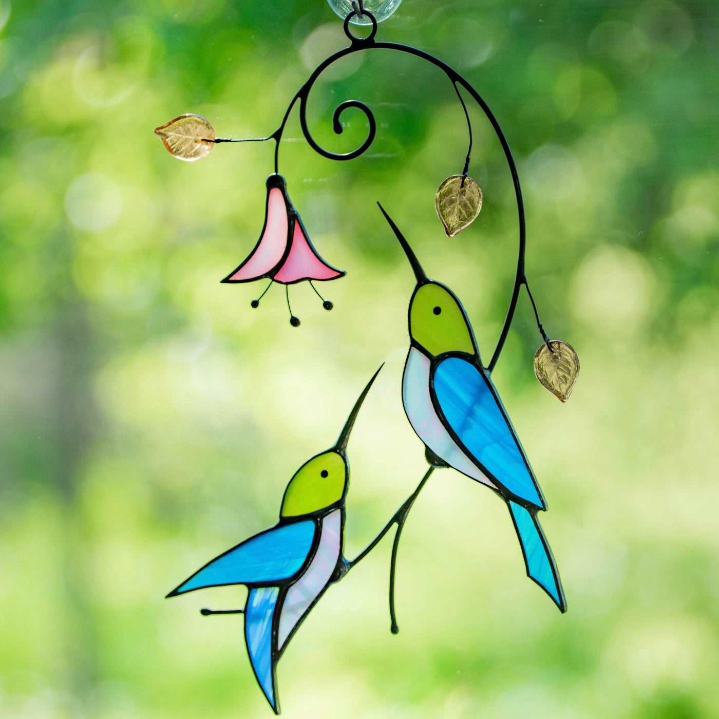 Pair of stained glass hummingbirds with a flower stained glass suncatcher
