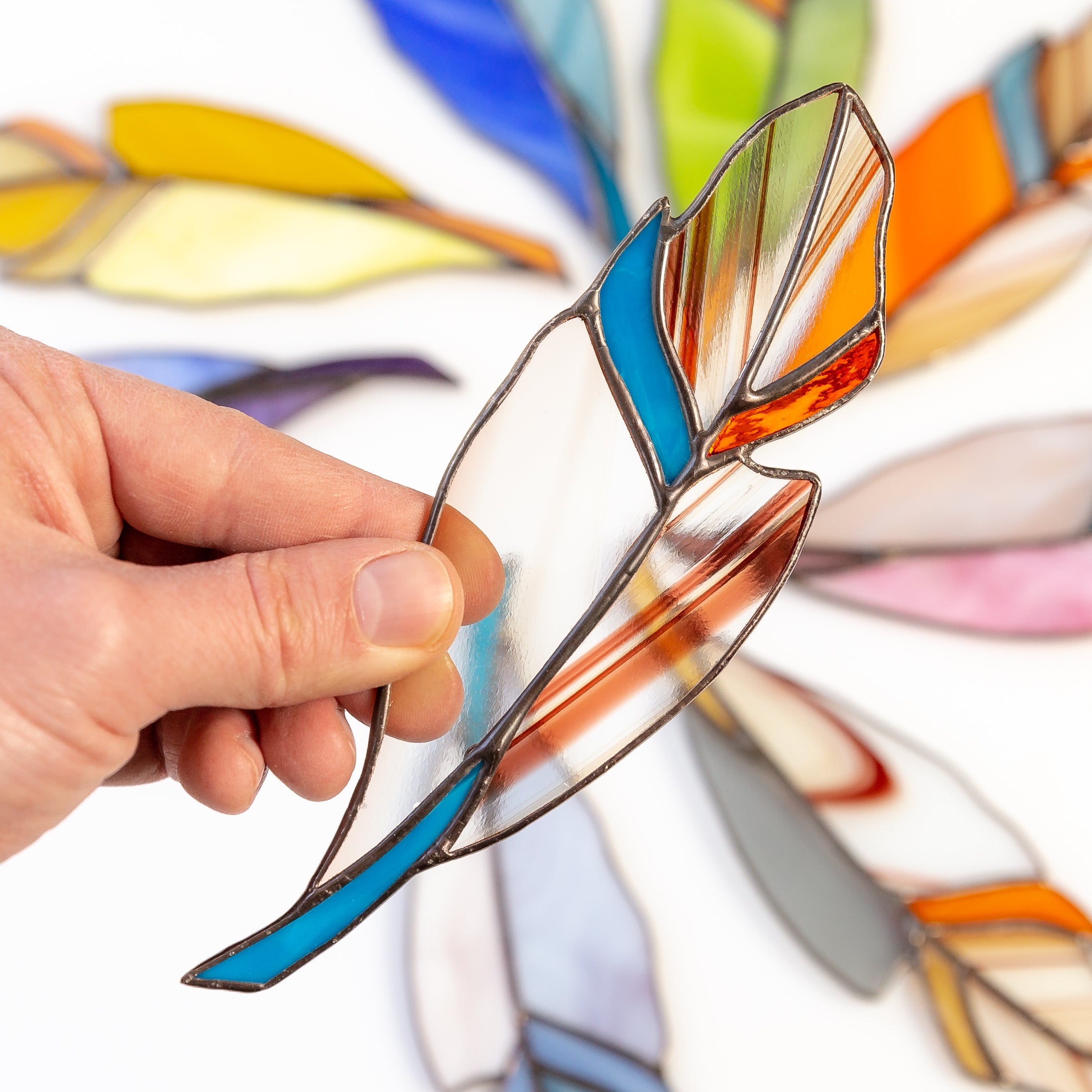 Suncatcher of a clear with blue parts stained glass feather