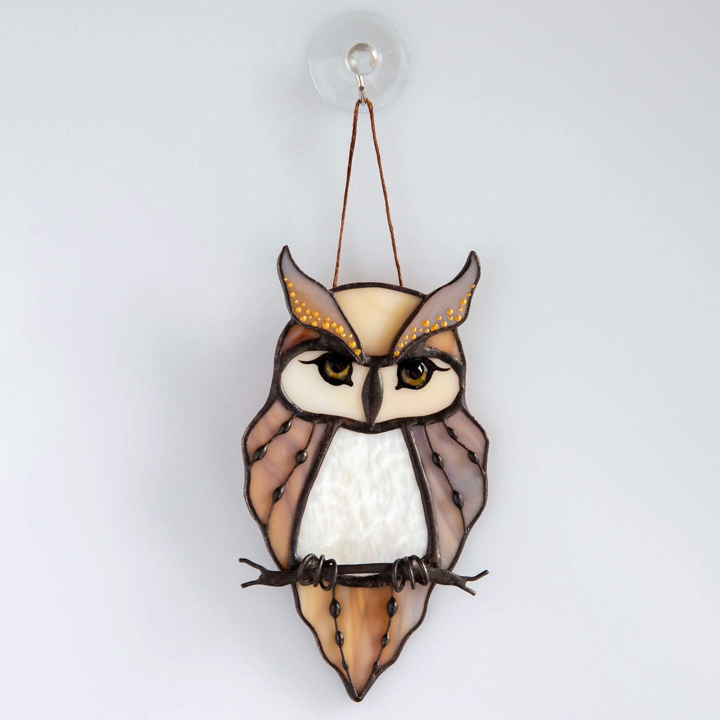 Stained glass horned owl sitting on the branch window hanging