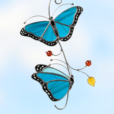 stained glass suncatcher of Blue Morpho butterflies on the branch  Edit alt text
