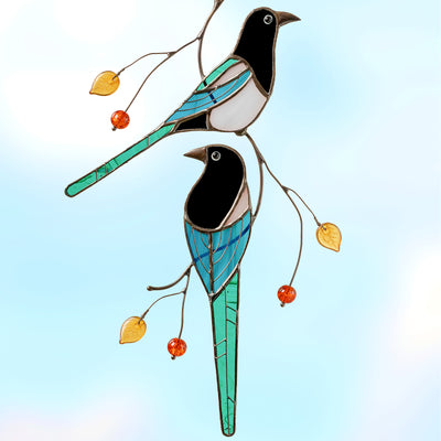 Two magpies sitting on the branch suncatcher of stained glass