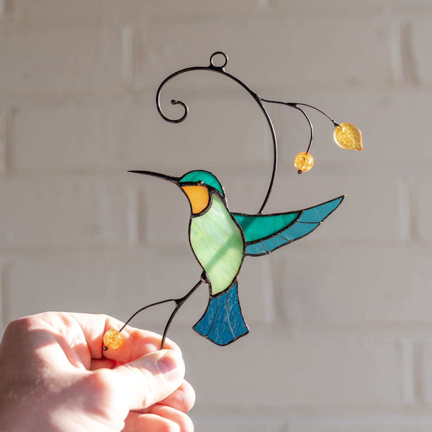 Suncatcher of a taking off the branch stained glass hummingbird