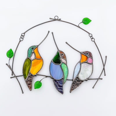 Three stained glass hummingbirds on the horizontal branch window hanging