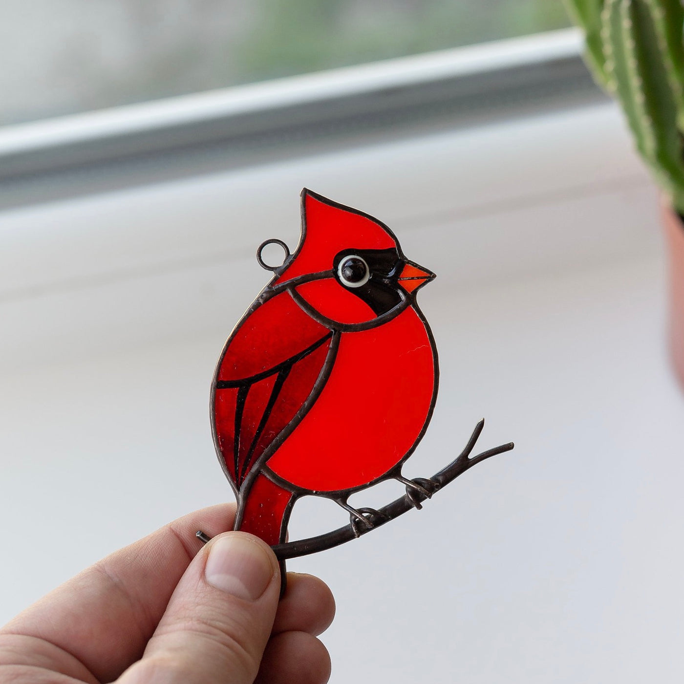 Stained glass red northern cardinal sitting on the branch window hanging