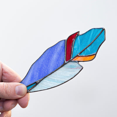 Zoomed stained glass blue feather suncatcher with shades of blue, orange and red
