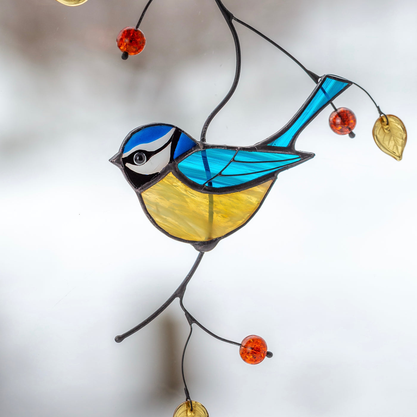 Stained glass blue chickadee on the branch window hanging 