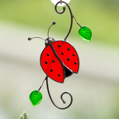 Window hanging of a ladybug with leaves of stained glass