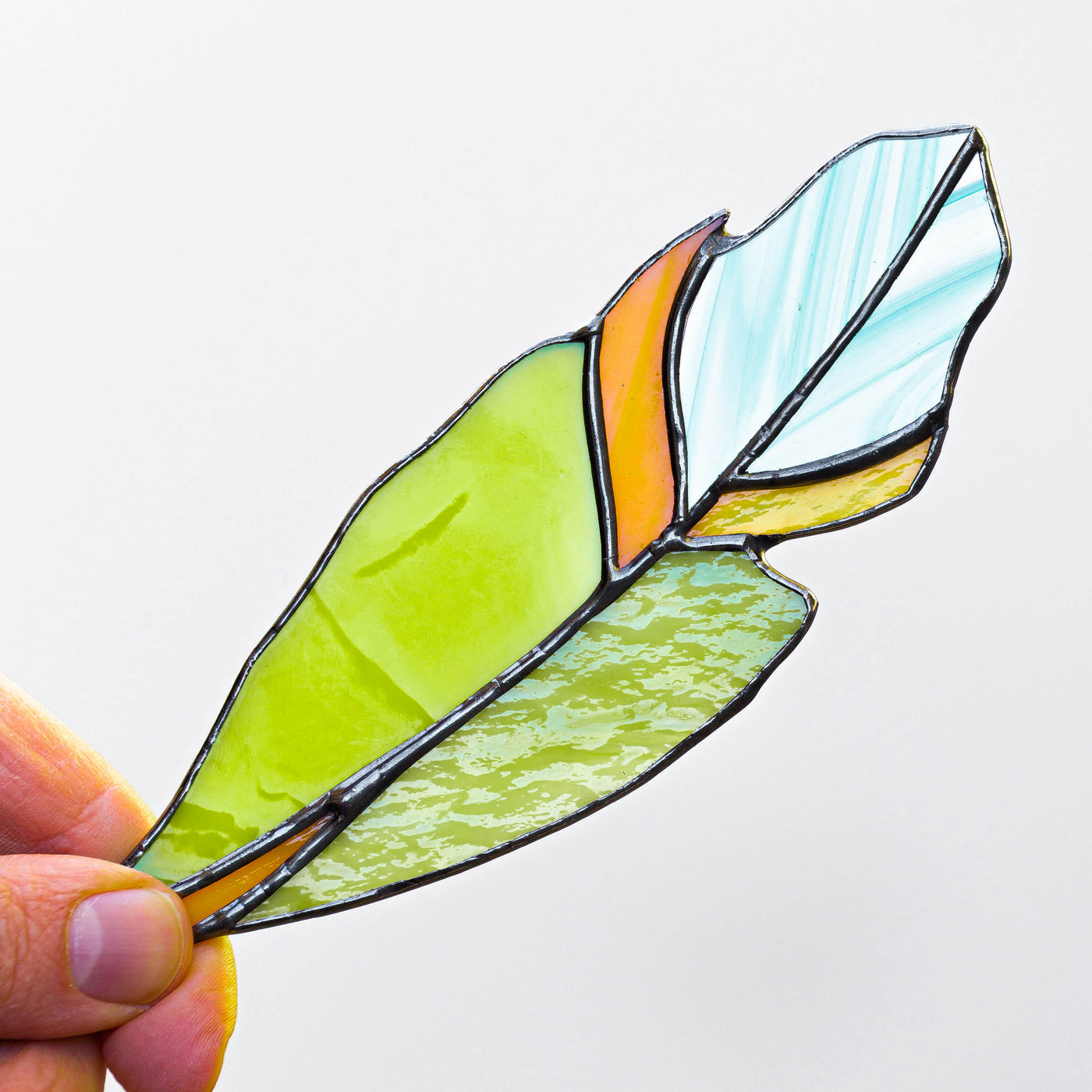 Stained glass window hanging of a green feather