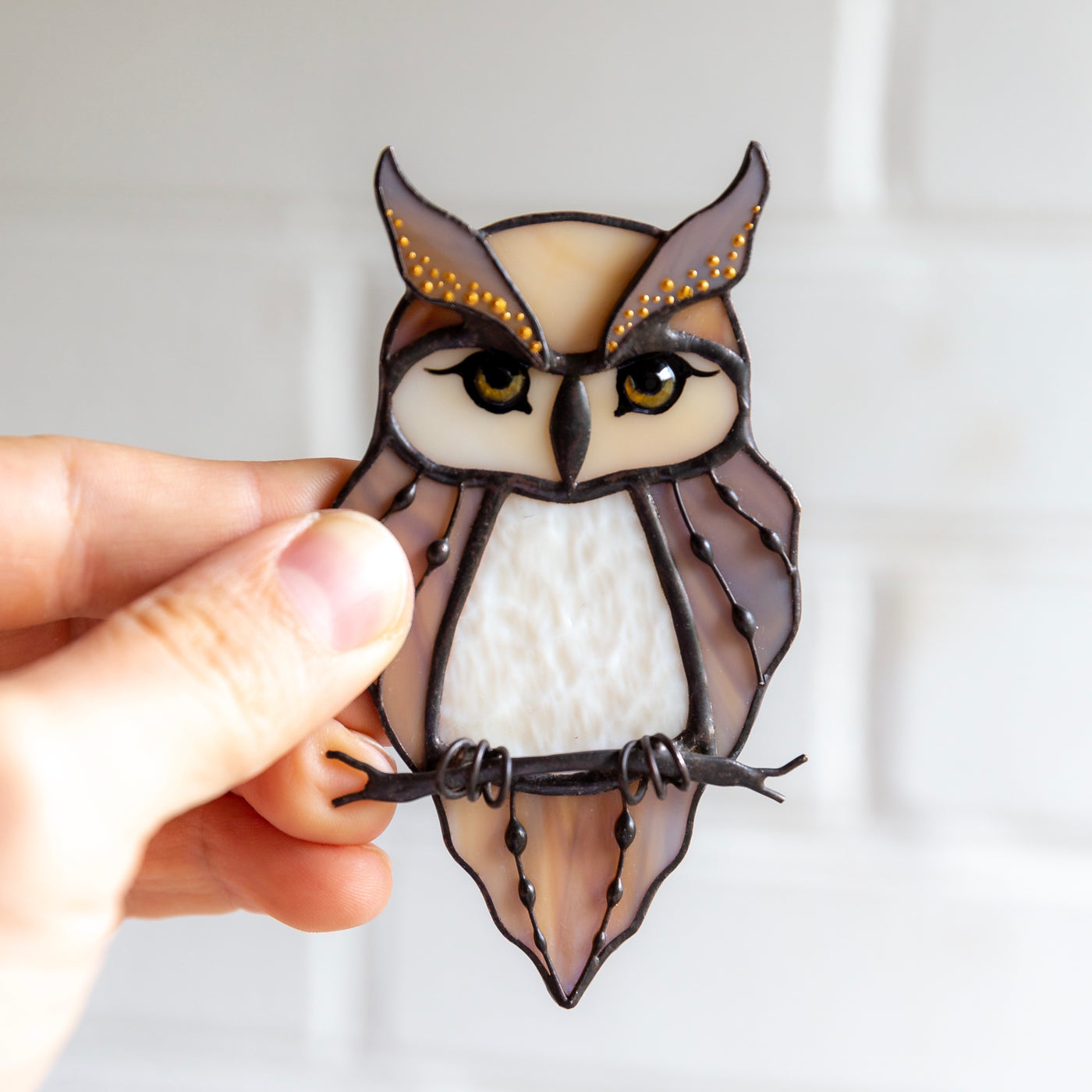 Suncatcher of a stained glass horned owl on the branch