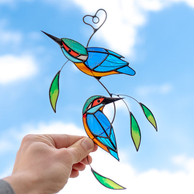 Stained glass suncatcher of a pair of kingfishers with leaves