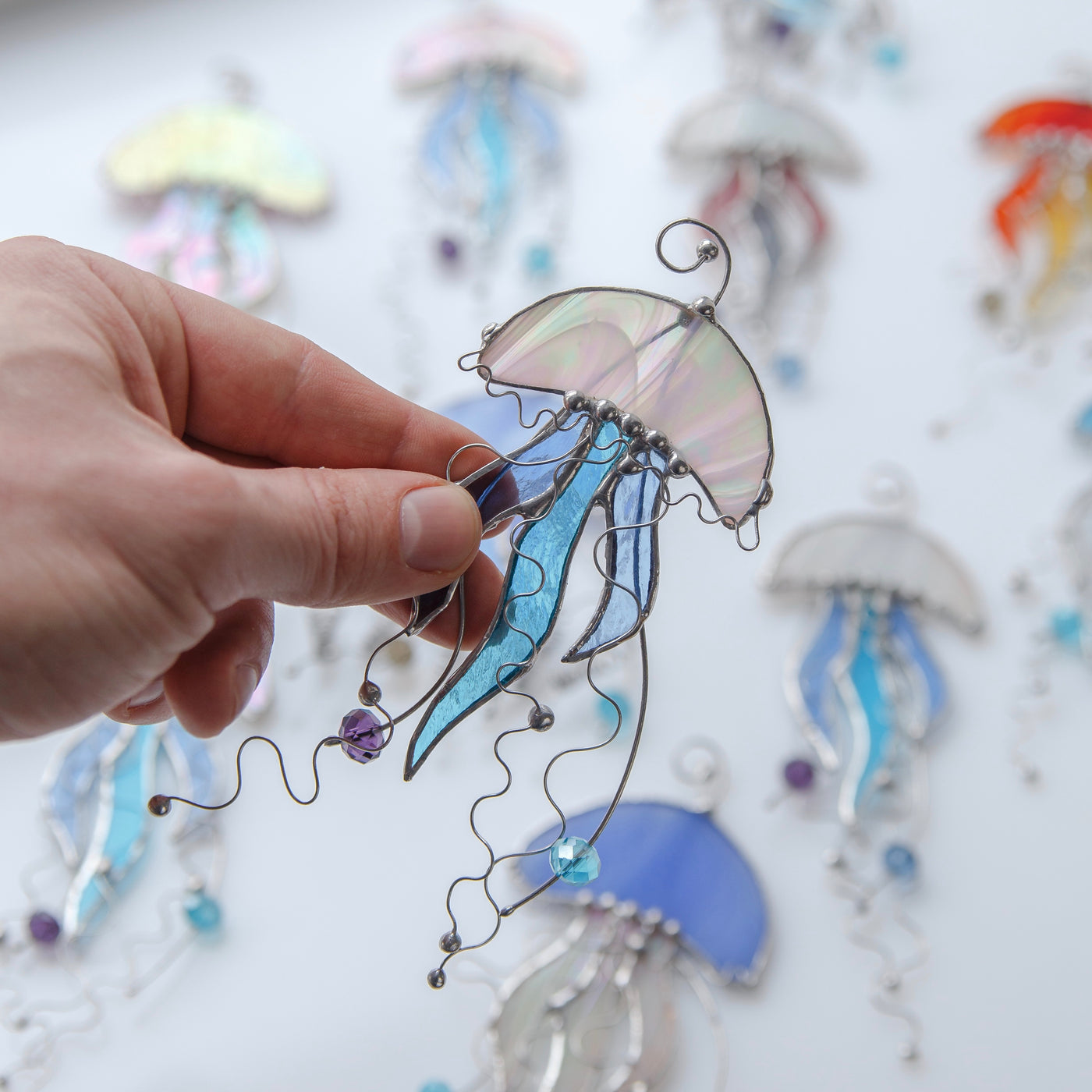 White stained glass jellyfish with blue tentacles window hanging