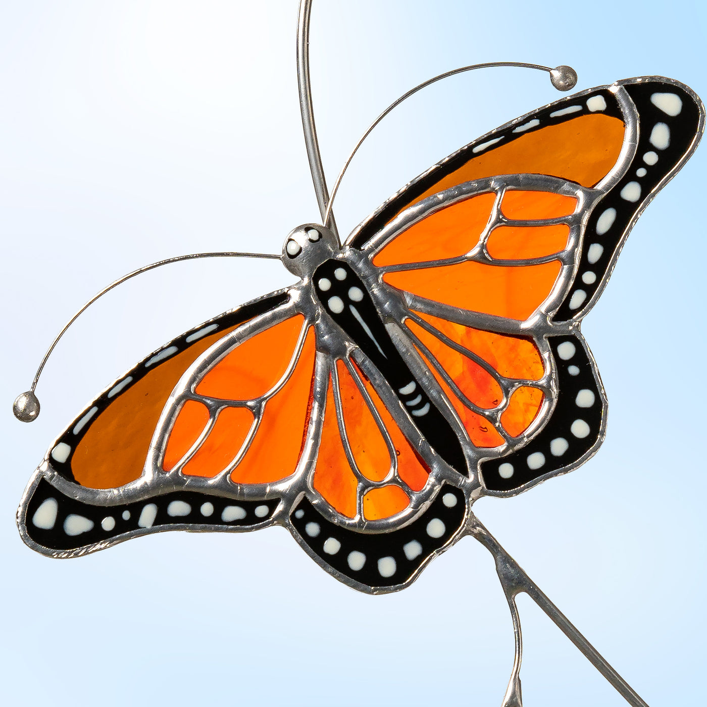 Detailed view of stained glass monarch butterfly, focusing on intricate wing pattern and craftsmanship.
