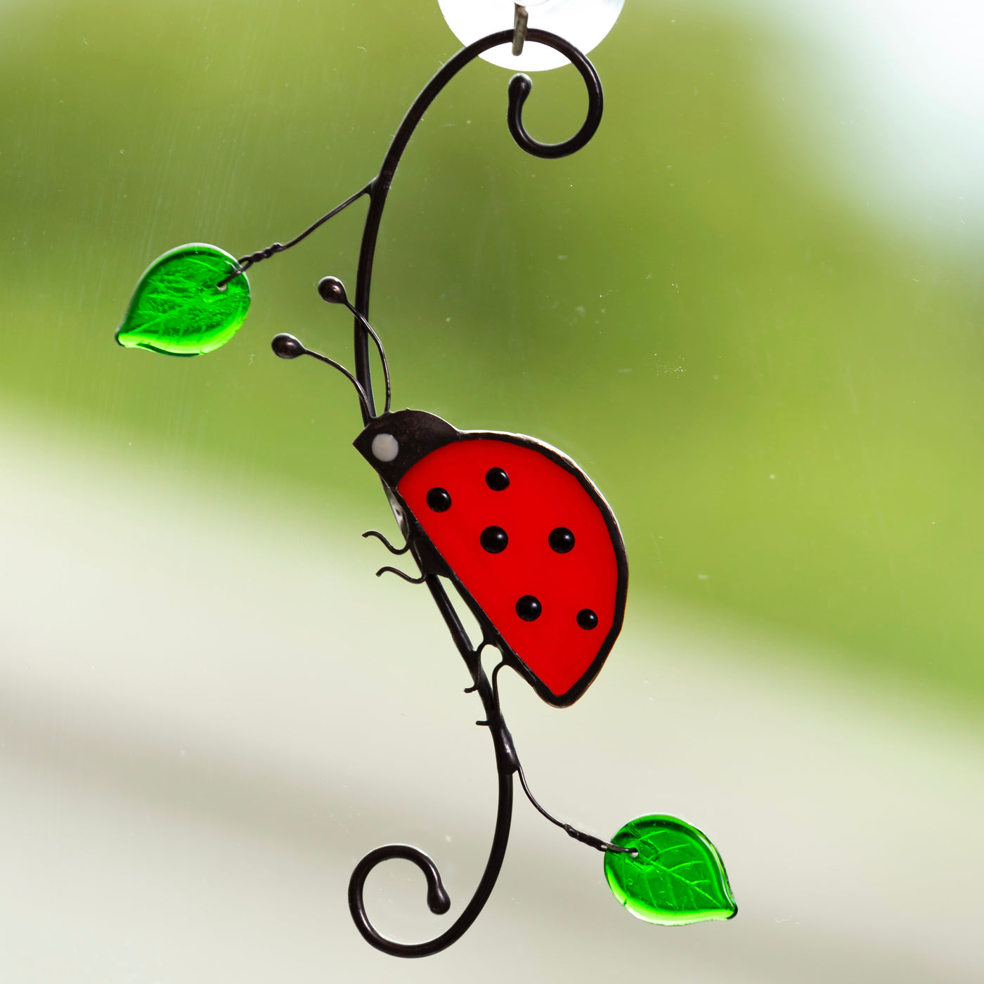 Side-view stained glass ladybug sitting on the branch suncatcher