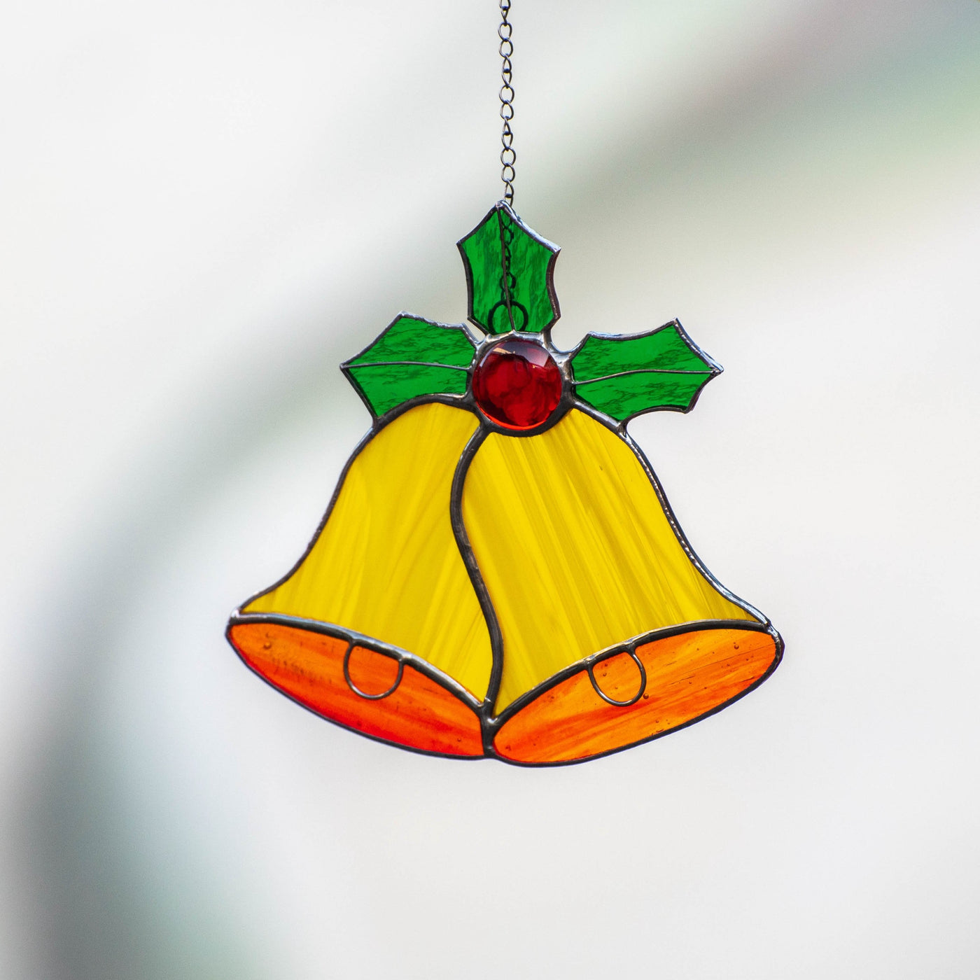 Stained glass yellow christmas bells suncatcher with holly leaves on top