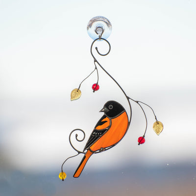 Stained glass Baltimore oriole sitting on the branch window hanging