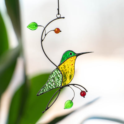 Stained glass green hummingbird with yellow belly sitting on the branch suncatcher