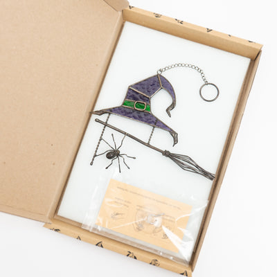 Purple witch's hat with broom and spider suncatcher in a brand box