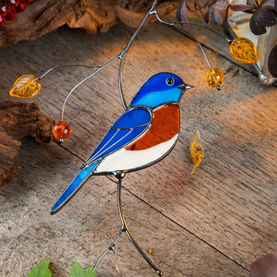 Stained glass suncatcher of a bluebird sitting on the branch
