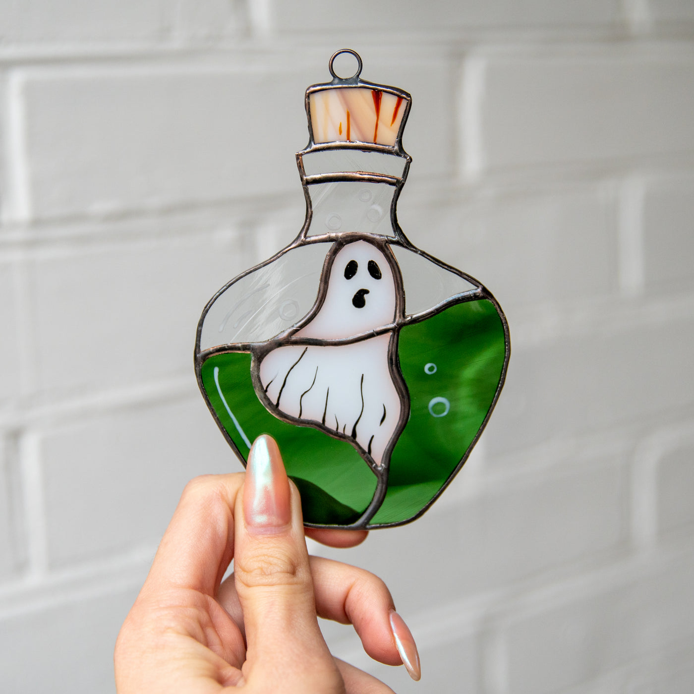 Spooky Halloween suncatcher of stained glass ghost in the bottle