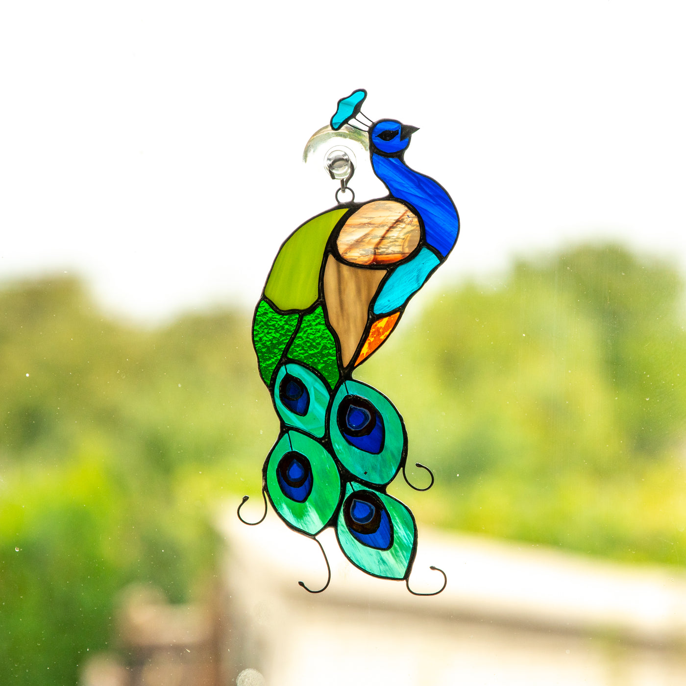 Bright peacock suncatcher of stained glass