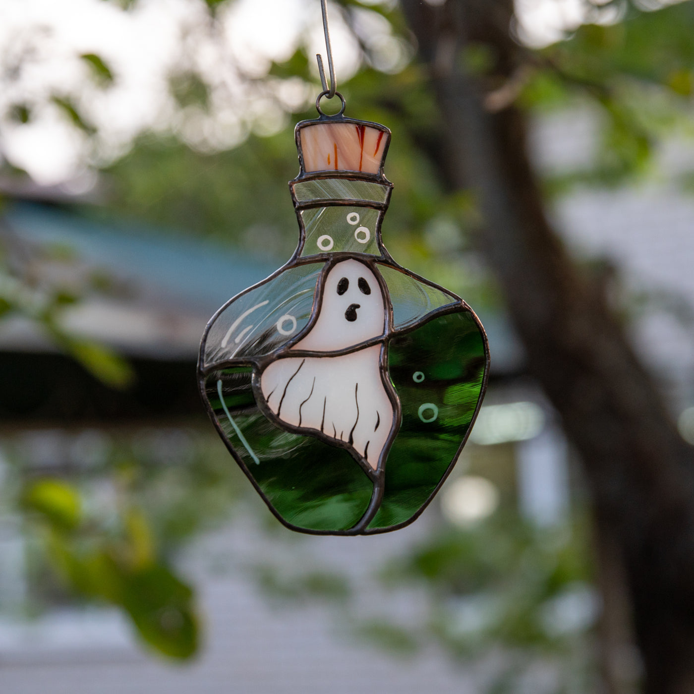 Stained glass ghost in the bottle window hanging for ghastly Halloween decor