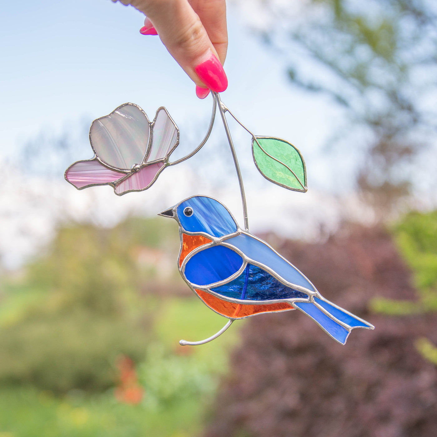 Stained glass bluebird with the pink flower above suncatcher