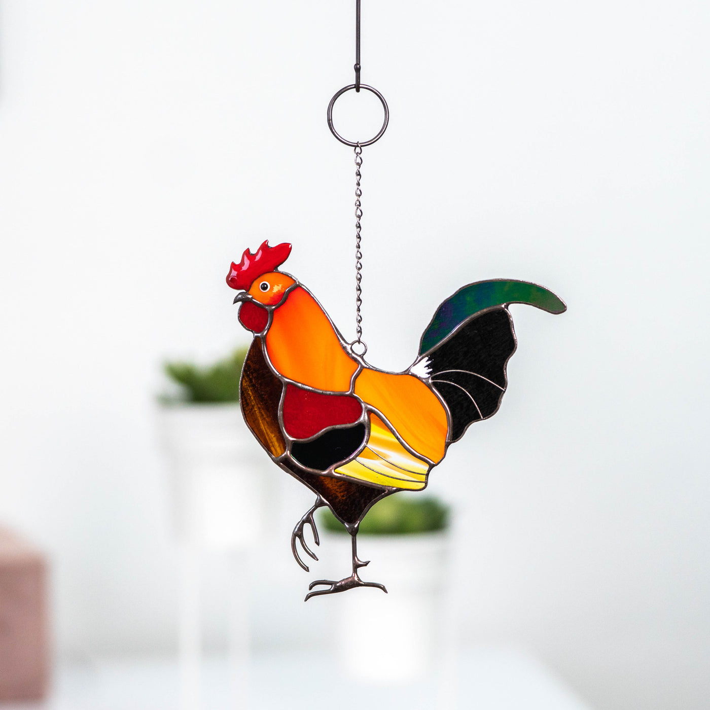 Bright stained glass window hanging of a rooster looking left