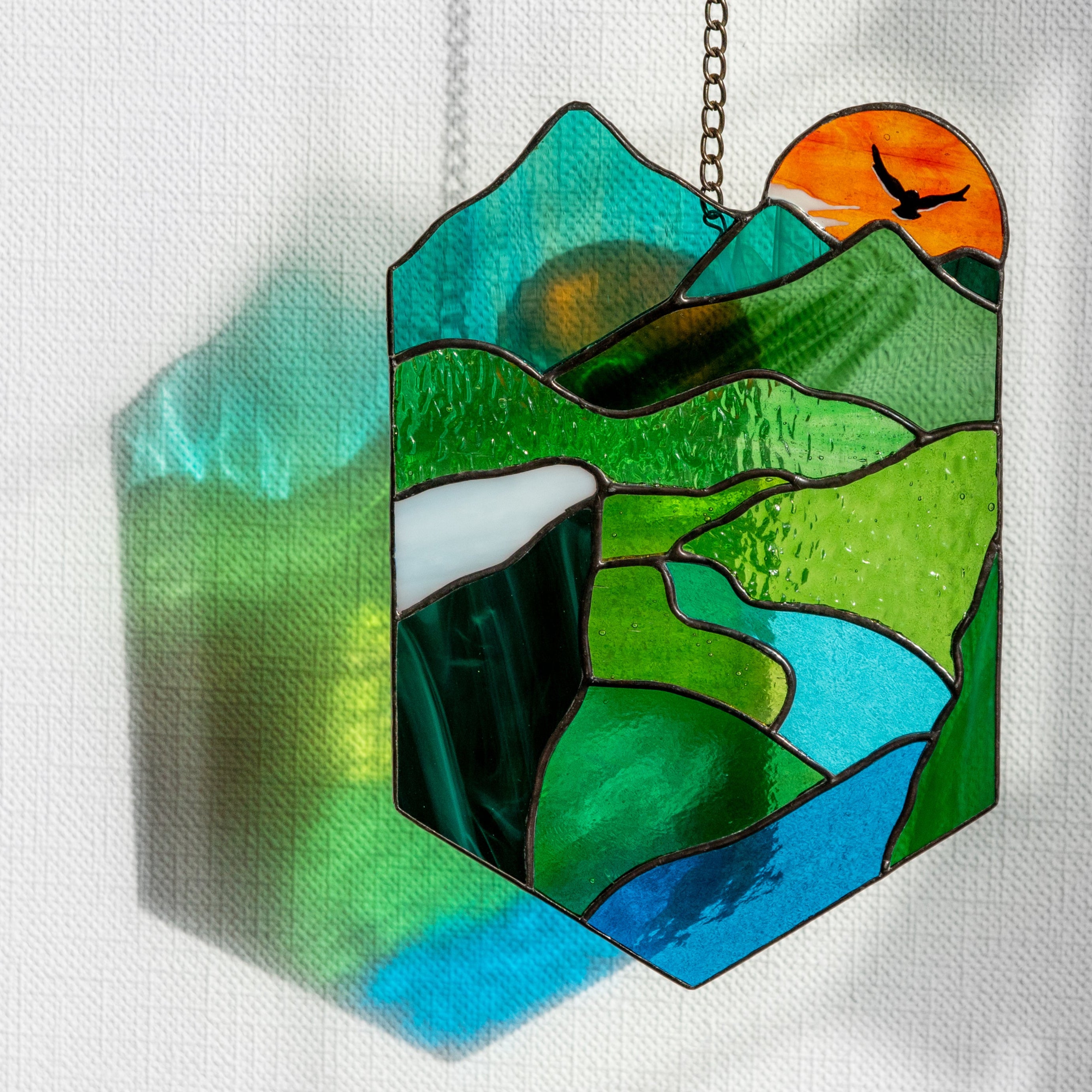 Stained glass panel depicting the sun and landscape 