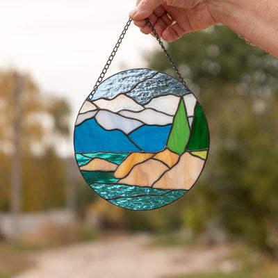 Stained glass round panel depicting the landscape of Lake Tahoe 