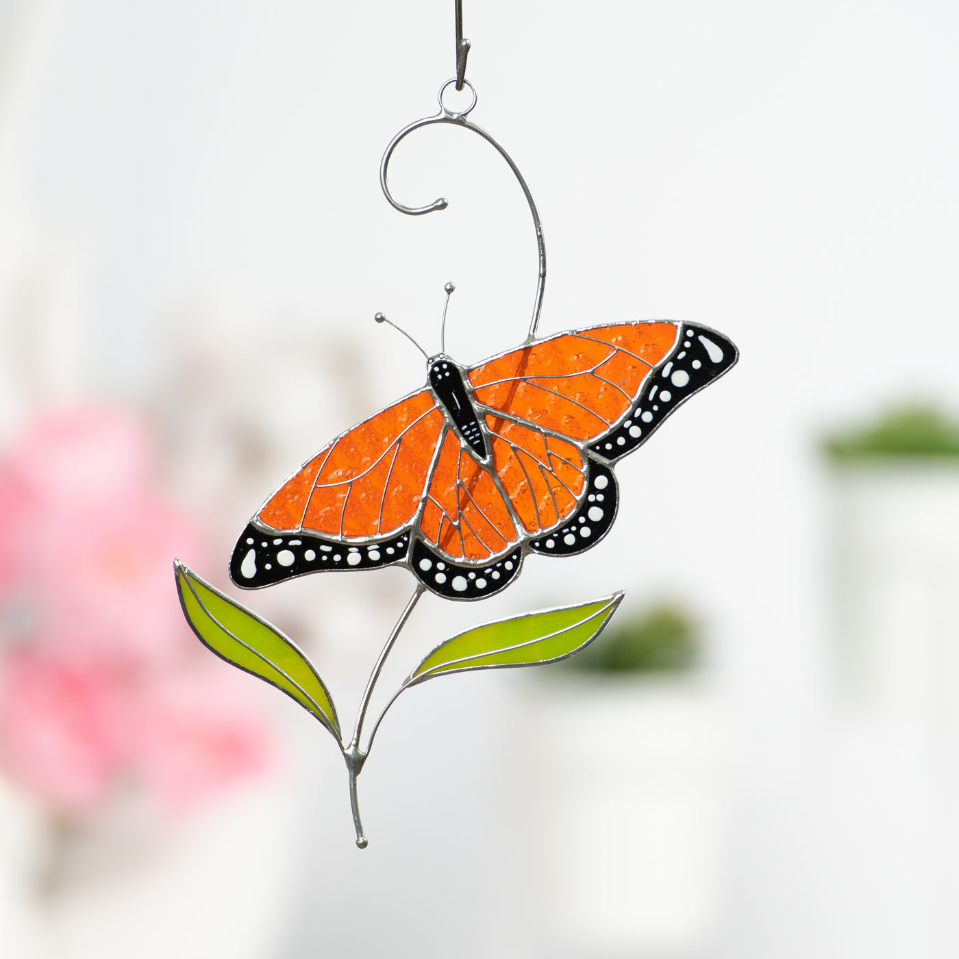Stained glass monarch butterfly with two green leaves suncatcher