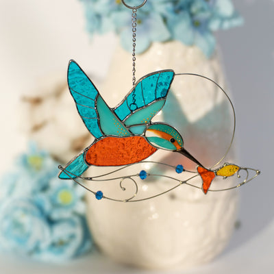 Stained glass window hanging of a kingfisher with the fish