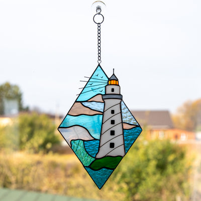 Stained glass rhombus panel depicting a white lighthouse in the waters