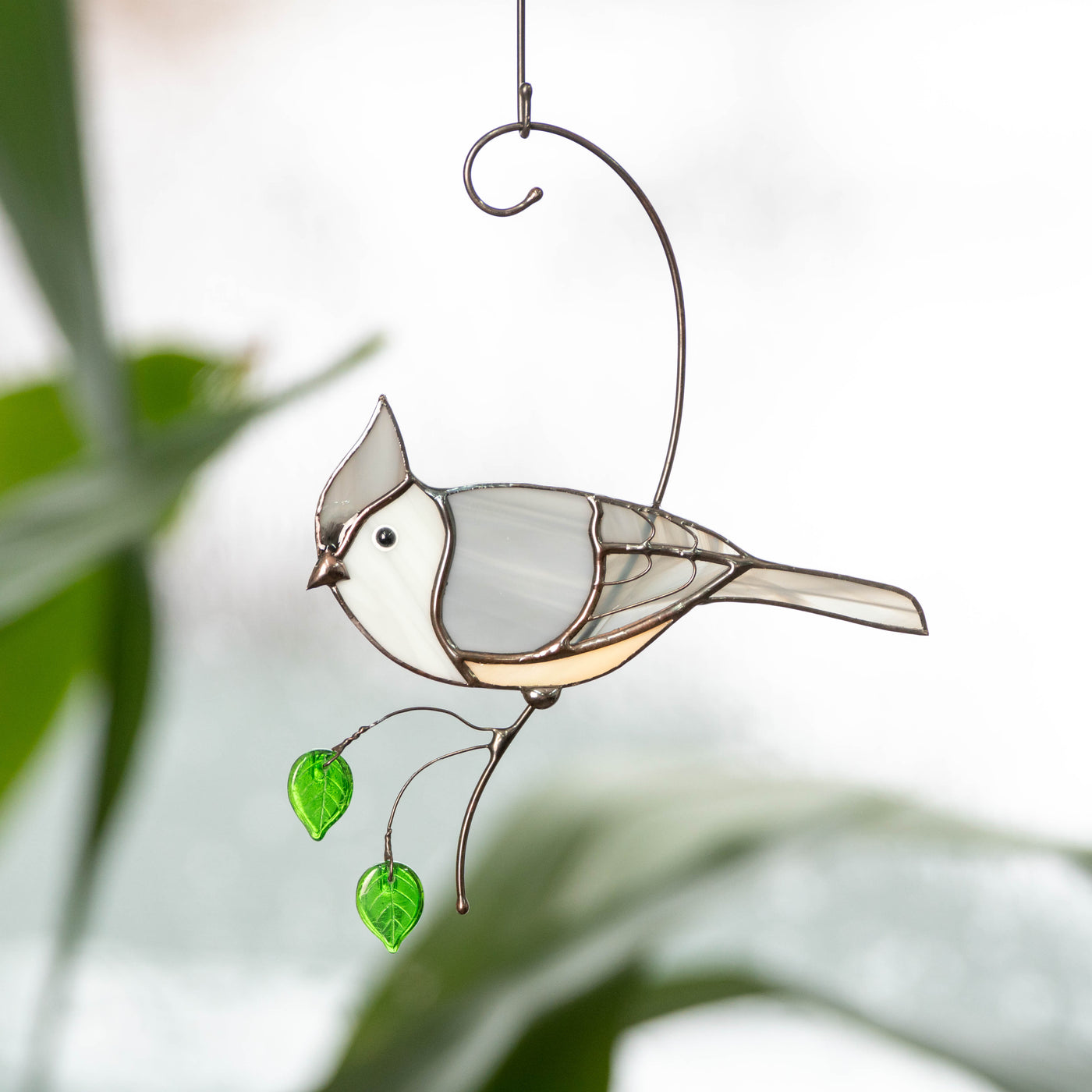 Stained glass titmouse sitting on the branch with green leaves window hanging 