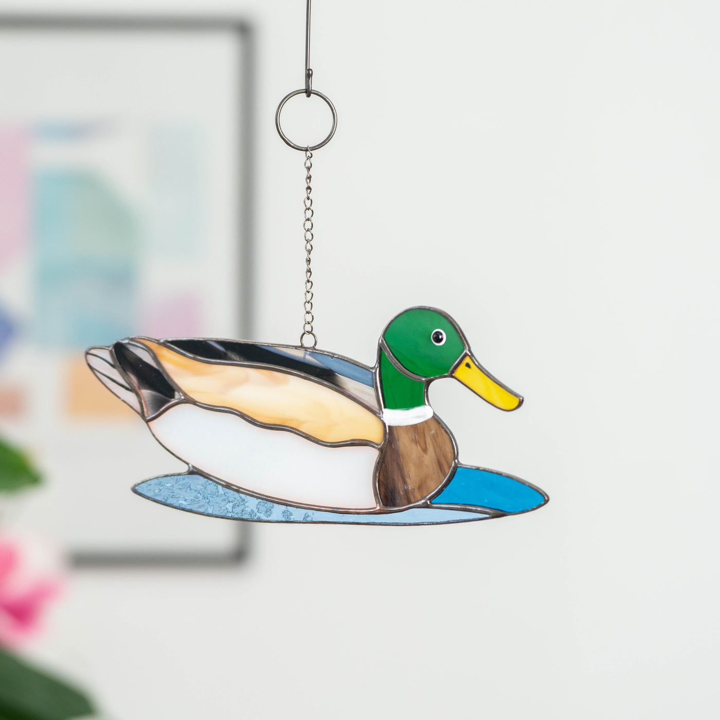 Bright stained glass window hanging of a duck looking right