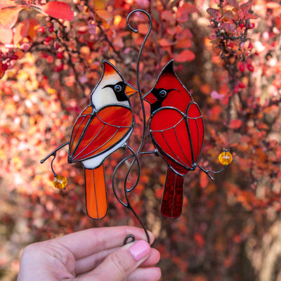 Stained glass red winter birds couple sitting on the branch with leaves and berries suncatcher