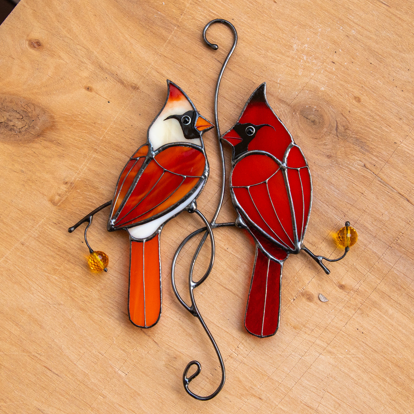 Stained glass window hanging of two cardinals in love