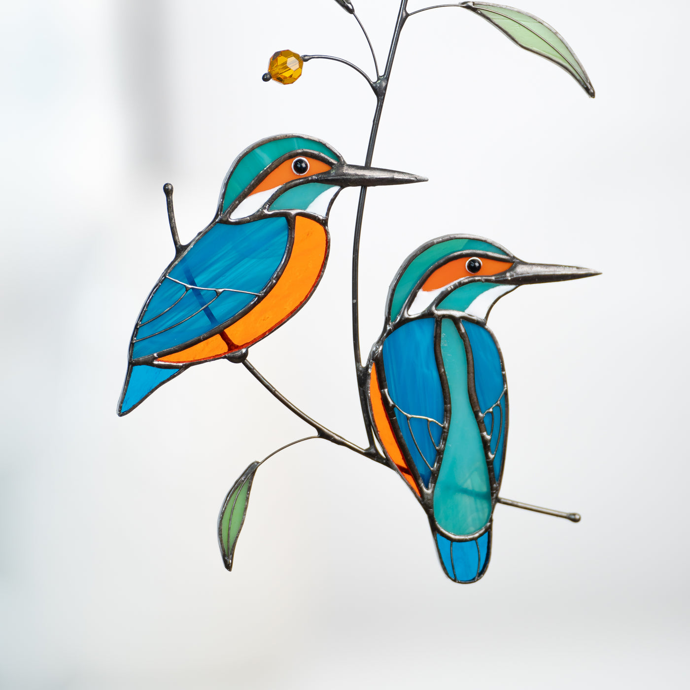 Zoomed two kingfishers sitting on the branch suncatcher