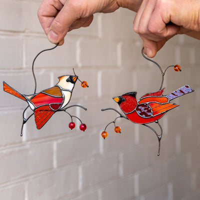 Two cardinals sitting on branches with berries window hanging made of stained glass