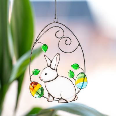 Easter bunny in a wired egg with two eggs on each side suncatcher of stained glass