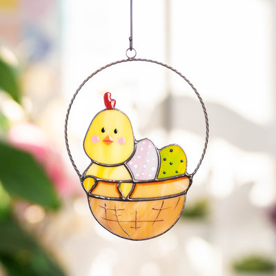 Bright stained glass suncatcher of chick with eggs in a basket for Easter