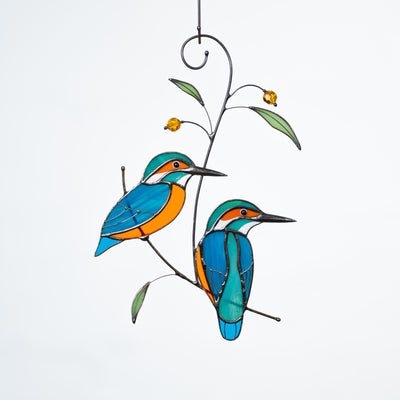 Stained glass couple of kingfishers on the branch with leaves and berries