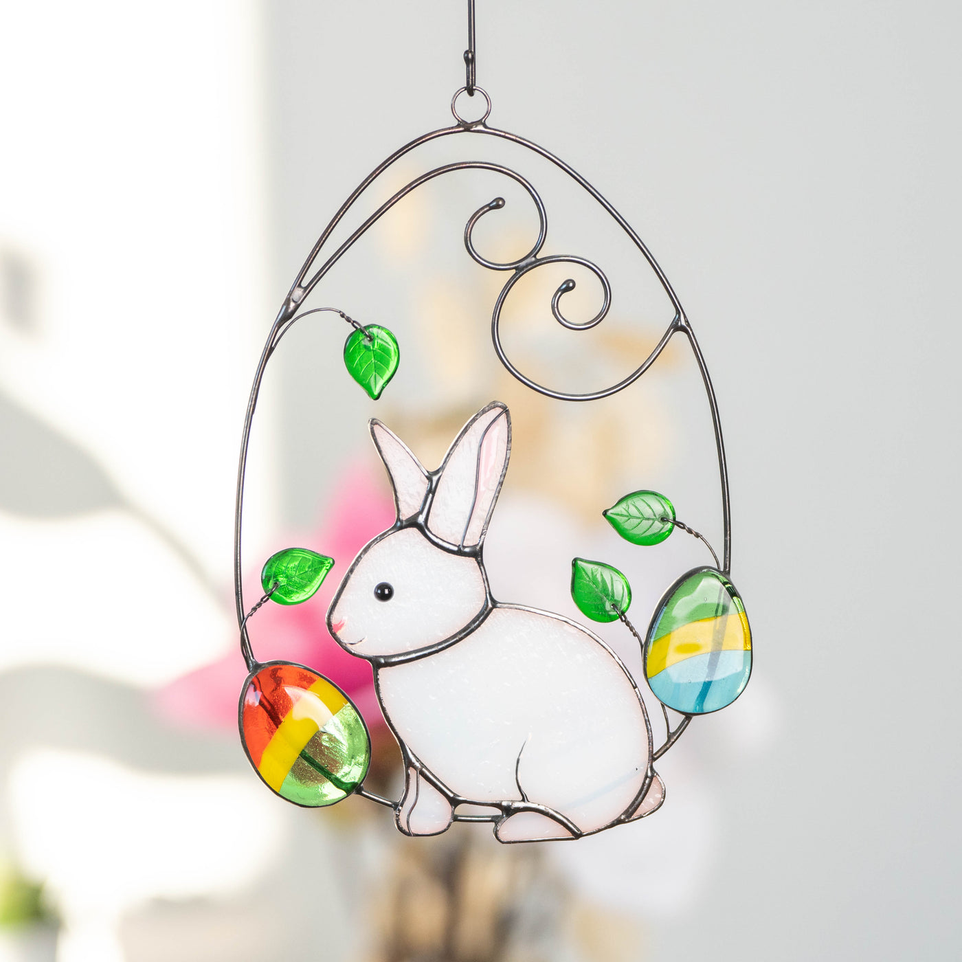 Stained glass window hanging of Easter bunny in a wired egg with two eggs on each side