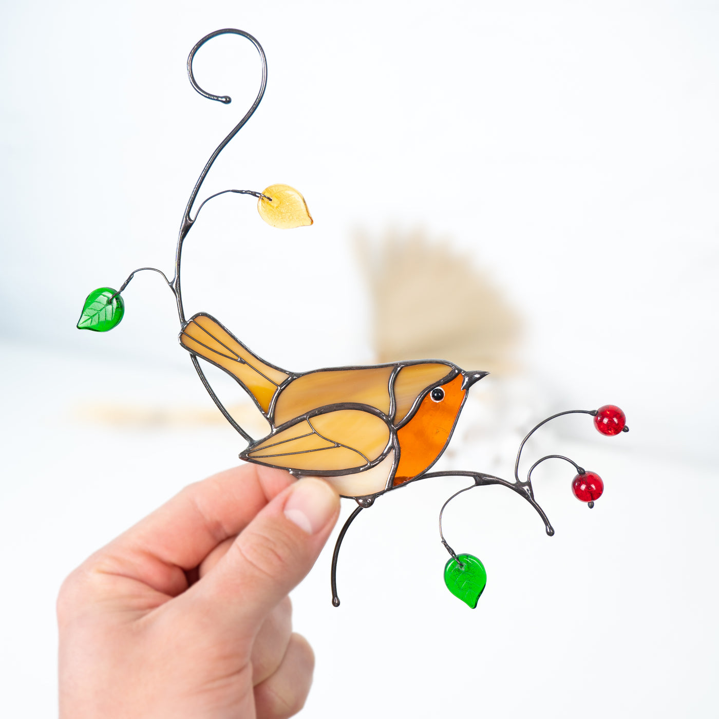 Stained glass suncatcher of a robin siting on the branch 