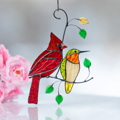 Zoomed stained glass window hanging of cardinal and hummingbird 