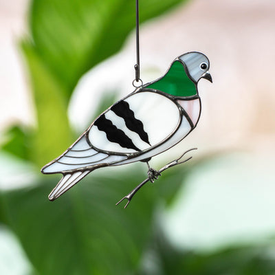 Stained glass window hanging of a pigeon sitting on the branch 