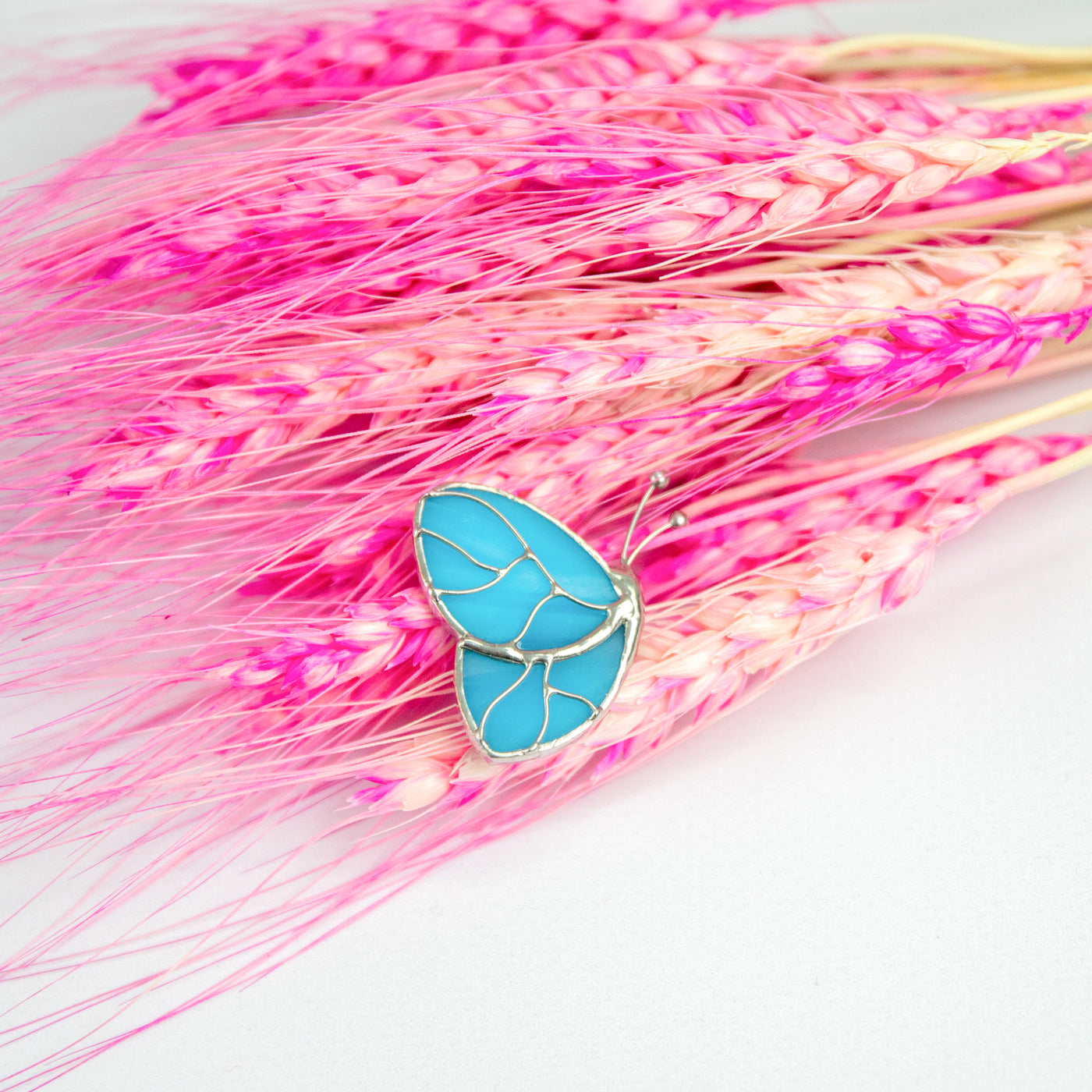 Stained glass brooch of a blue butterfly