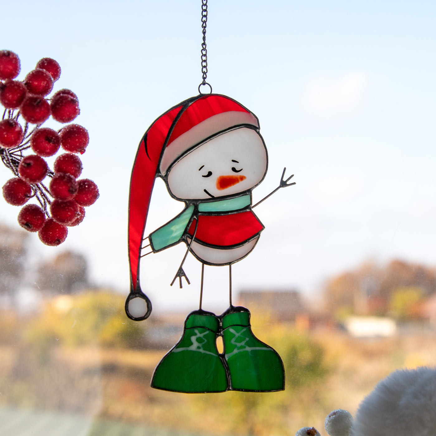Snowman in a red hat and green boots window hanging of stained glass