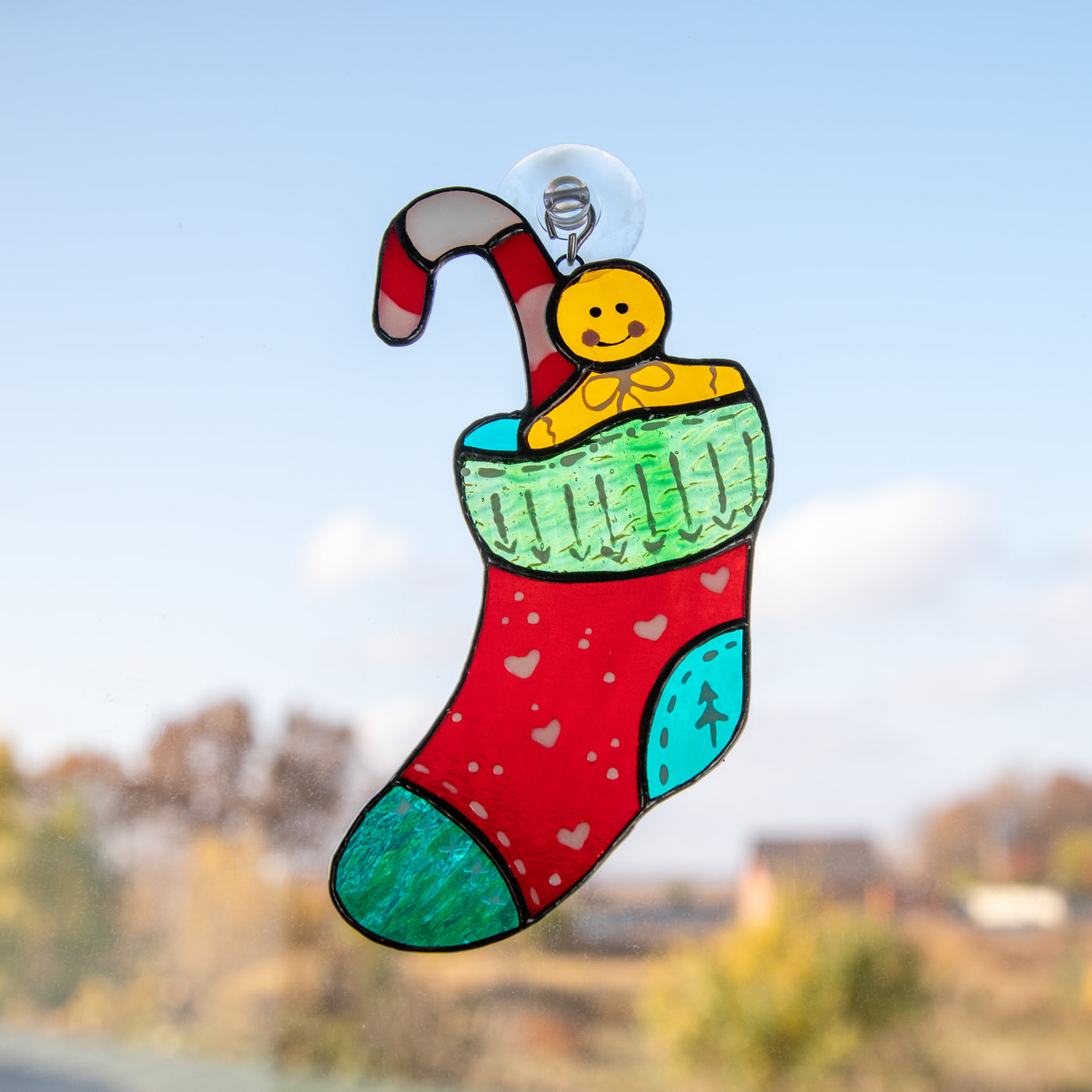 Stained glass suncatcher of Christmas stocking with candy cane and cookie